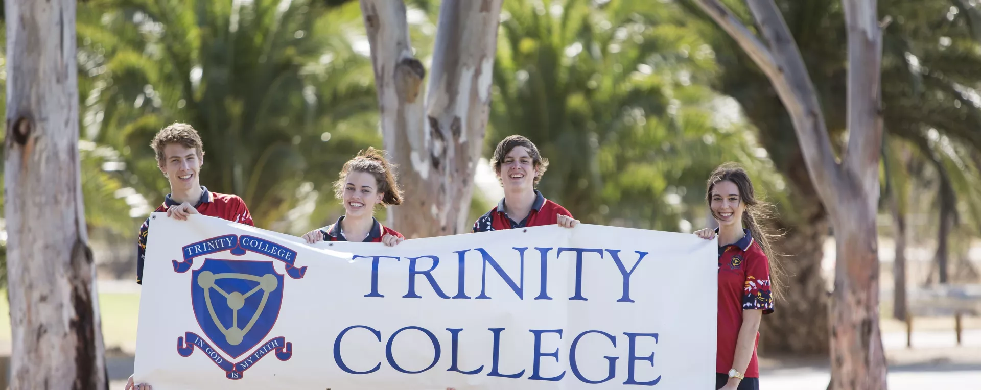 Students holding Trinity College Cocurricular banner